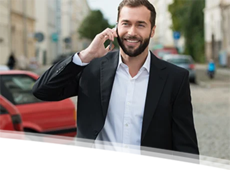 Mann telefoniert neben Auto