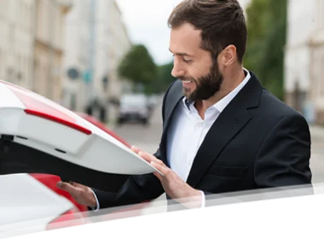 Mann steigt in Auto ein